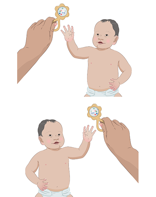 Child reaches for rattle with either hand